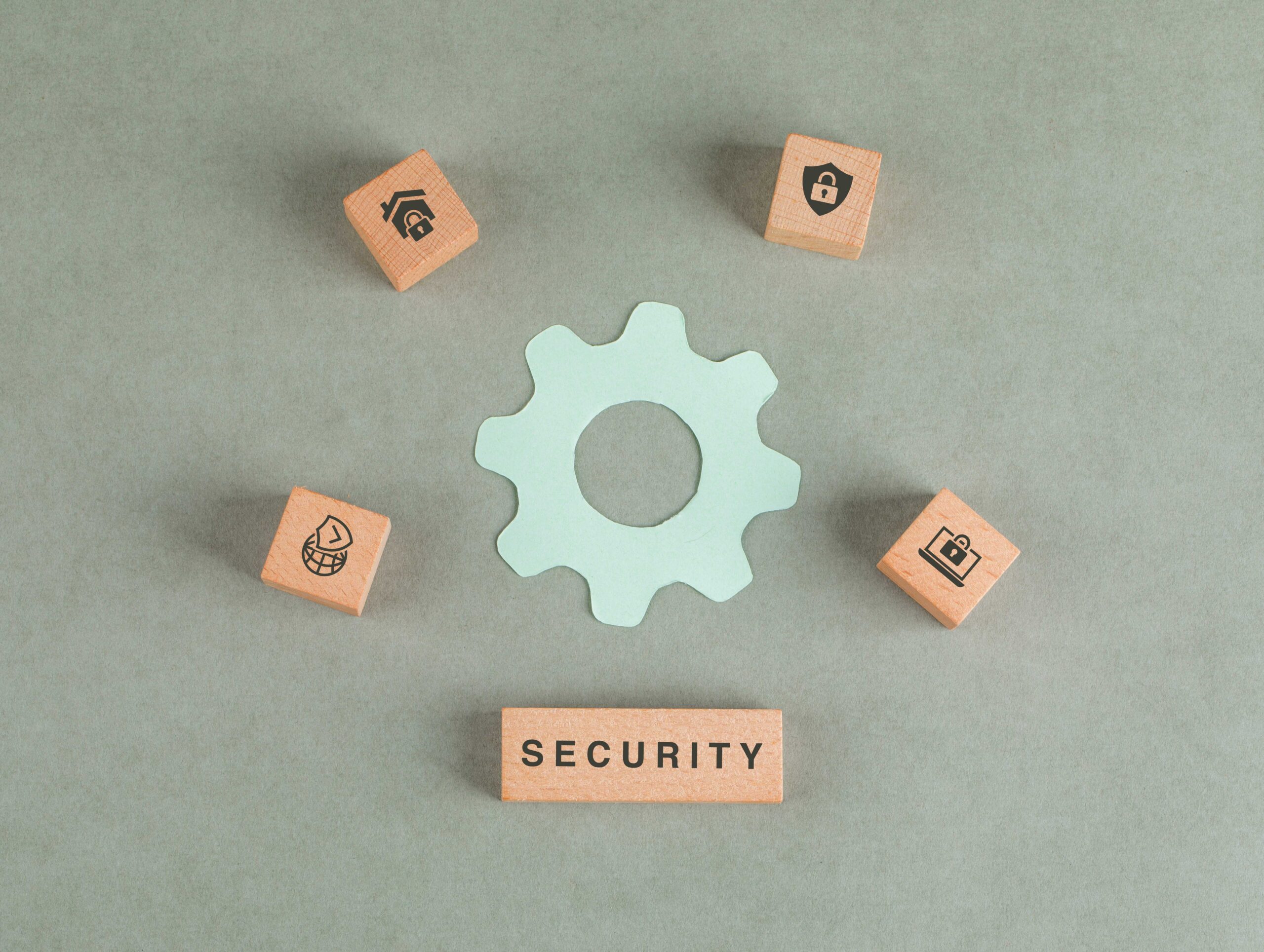 Conceptual of security with wooden blocks, paper settings icon on sage color background flat lay. horizontal image conceptual security with wooden blocks paper settings icon scaled Conceptual of security with wooden blocks, paper settings icon on sage color background flat lay. horizontal image